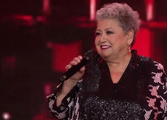 Ewa Bem w trakcie dynamicznego występu na scenie, oddająca pasję do muzyki.