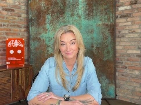Martyna Wojciechowska w dynamicznej pozie, symbolizującej jej podróże, ekstremalne wyzwania i zaangażowanie społeczne.