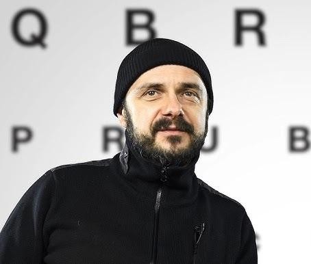 Arkadiusz Jakubik w trakcie pracy artystycznej, symbolizujący jego różnorodne role jako aktor, reżyser i muzyk.