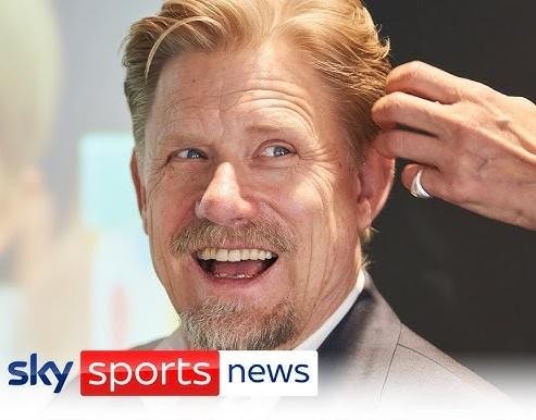 Peter Schmeichel, bramkarz Manchesteru United, w dynamicznej pozie na boisku, z intensywnym wyrazem twarzy.