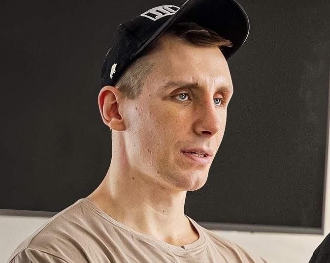 Michał Owczarzak (Owca WK) podczas wykonywania rekordu siłowego (martwy ciąg/przysiad/wyciskanie), z widocznym wysiłkiem i imponującą muskulaturą.