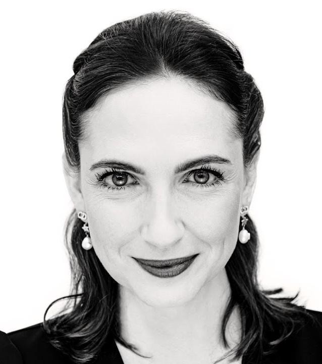 Anna Cieślak na scenie teatralnej, w dynamicznej pozie, oddająca emocje roli, z rozmytą widownią w tle.