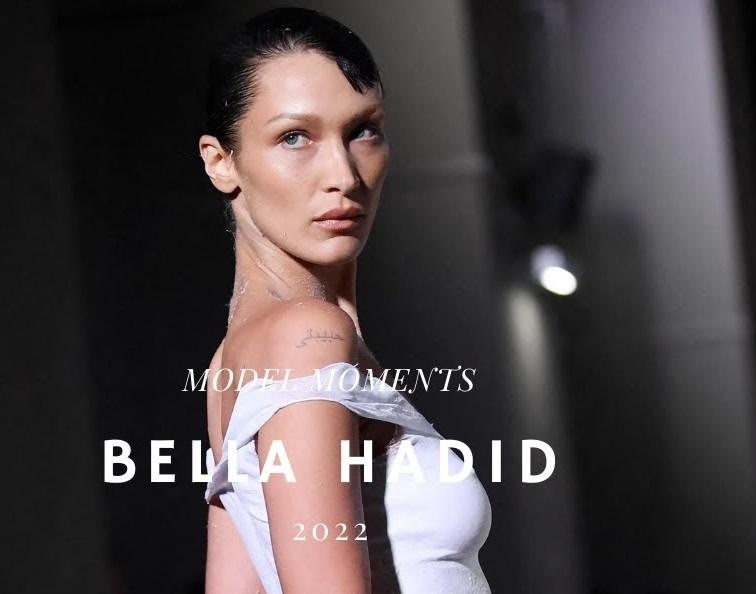 Bella Hadid na wybiegu podczas pokazu mody, w dynamicznej pozie, oddająca energię i profesjonalizm świata mody.